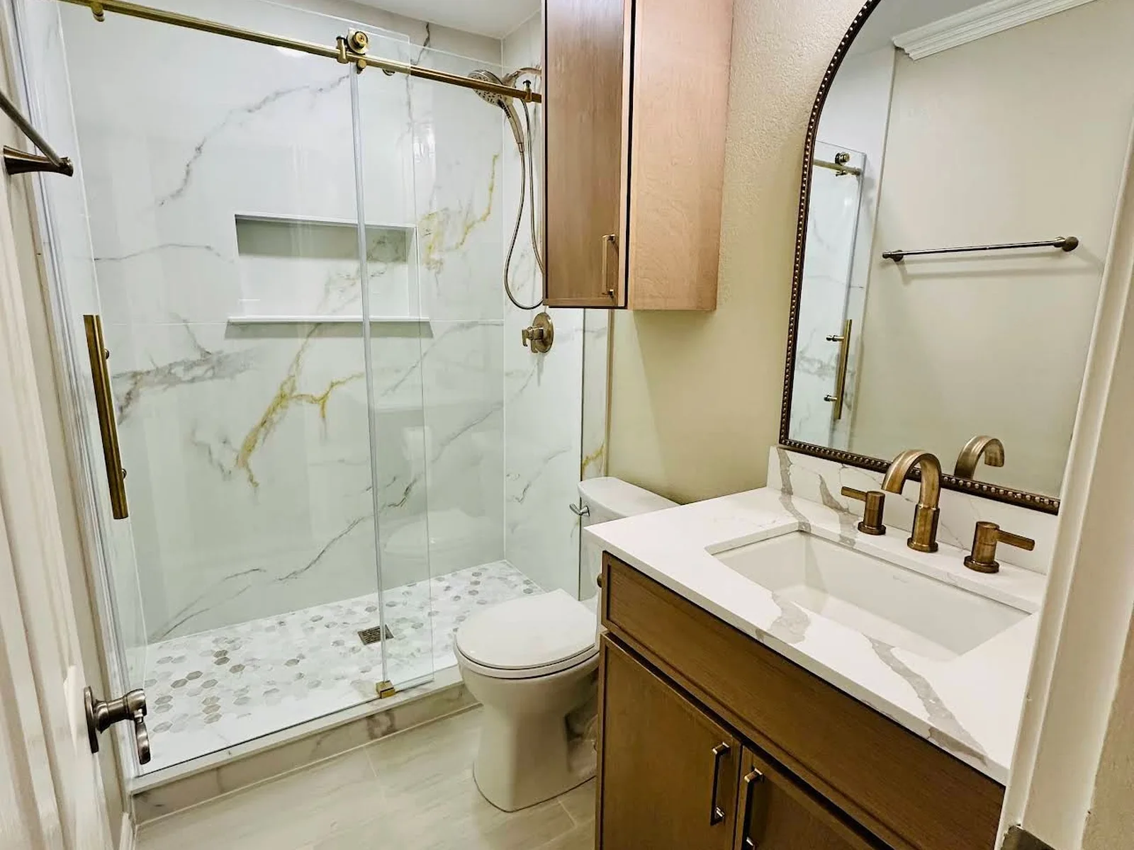 Tub-to-shower conversion with new vanity, countertop, mirror and lighting