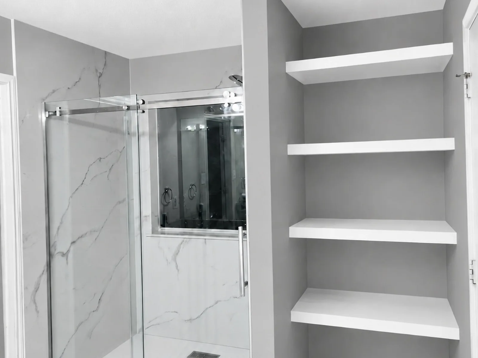 Tub-to-shower conversion with open linen storage and new finishes