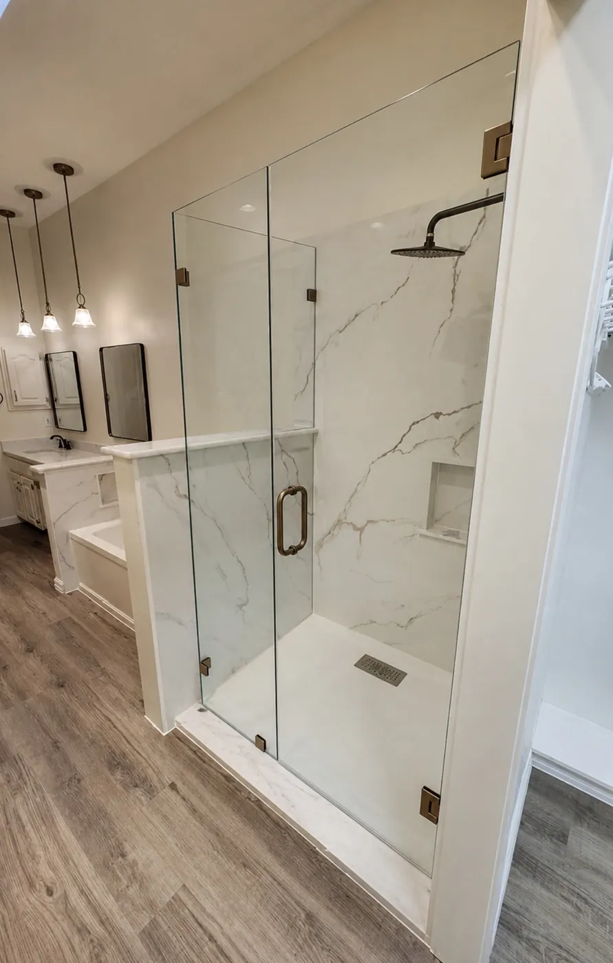 Bathroom remodel with walk-in shower, stone surround, composite base, Delta system, custom outswing glass door, tub replacement and wood-look flooring