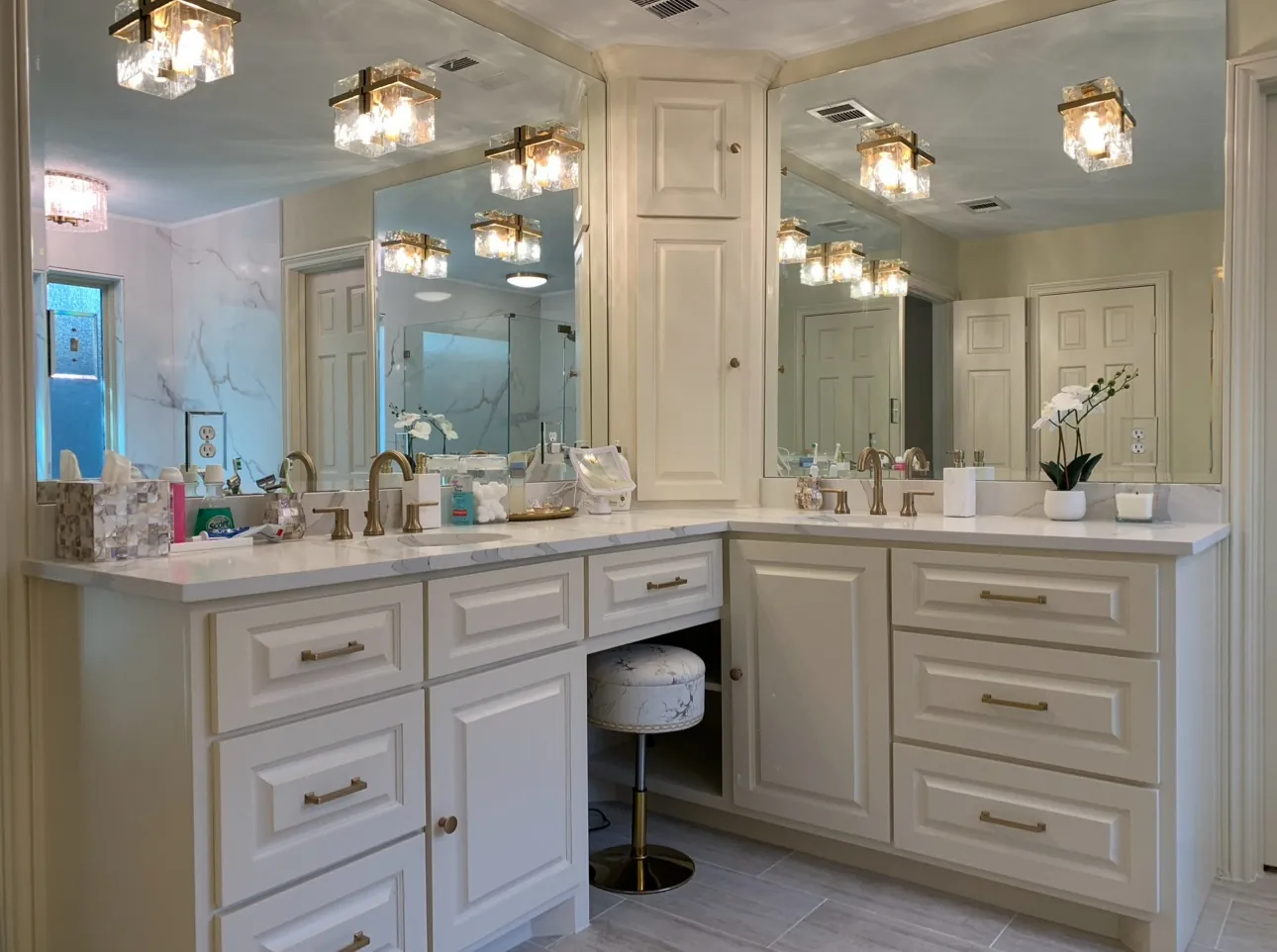 Custom bathroom vanity with quartz countertop, champagne bronze vanity lights, custom mirrors, makeup sitting area, wall cabinet and white cabinetry