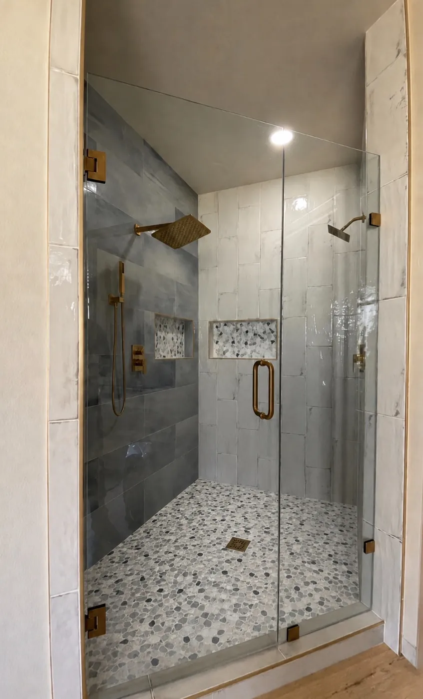 Custom shower remodel with dual champagne bronze system, blue and white wall tile, mosaic floor, niche inlays and frameless glass door