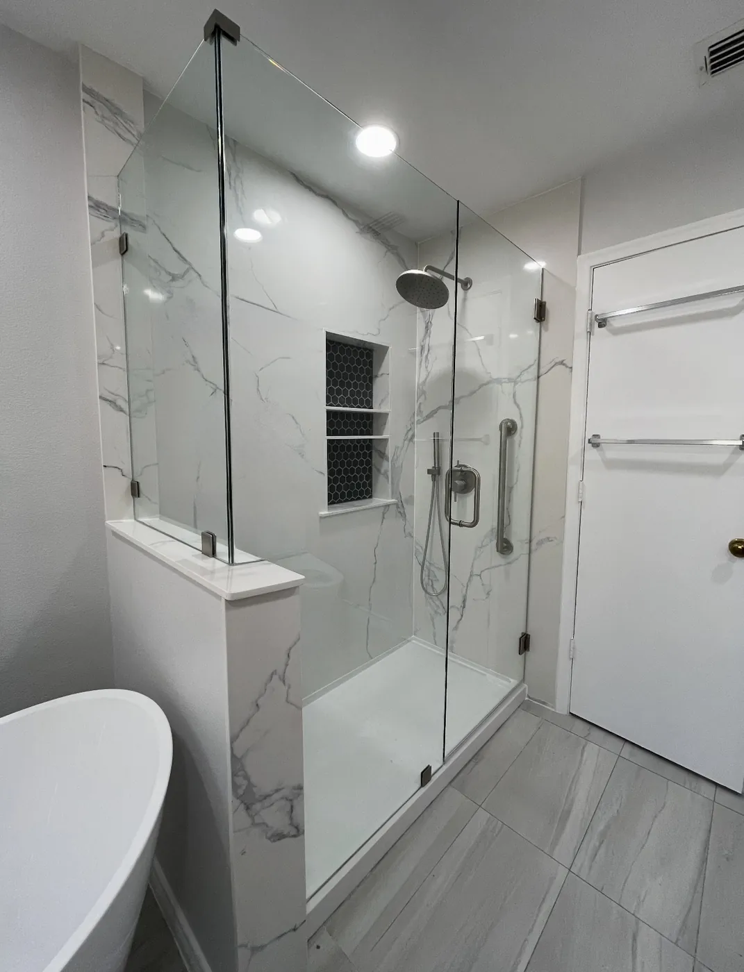 Bathroom remodel with walk-in shower, stone walls, mosaic niche, Delta system, grab bars, composite base, custom glass and freestanding tub