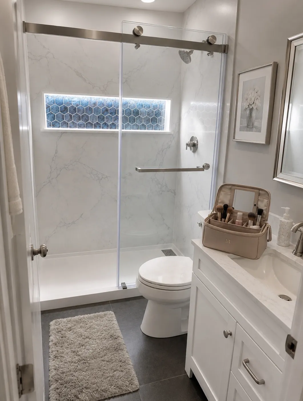 Tub-to-shower remodel with stone walls, composite base, brushed nickel system, sliding glass, illuminated blue niche, vanity, toilet and slate flooring