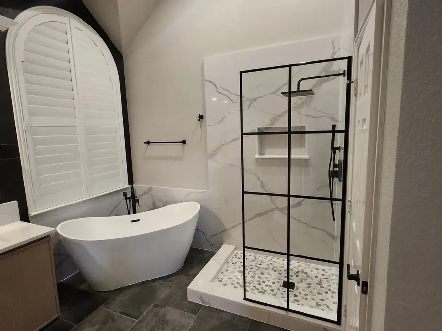 Luxury primary bathroom with black grid shower and freestanding tub