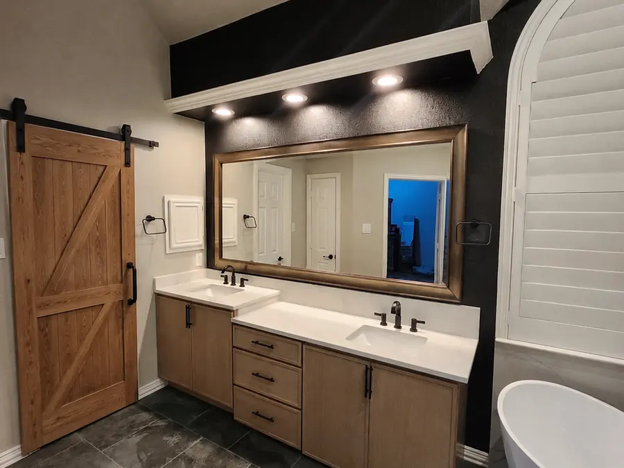 Oak vanity and barn door in remodeled bathroom